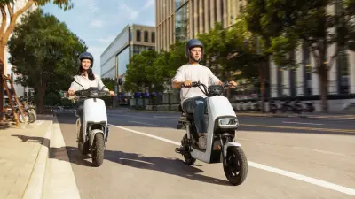 Couple riding electric scooters in a city.